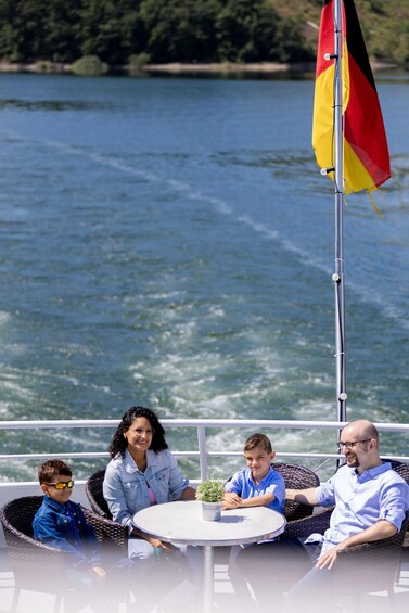 A family of four on a boat with a flag. 1