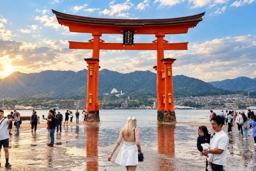 A red torii gate with a mountain backdrop and a crowd of people. 5
