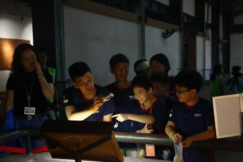 A group of people gathered around a table with a laptop and a projector. 5