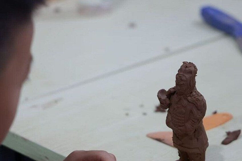 A person holding a clay sculpture. 3