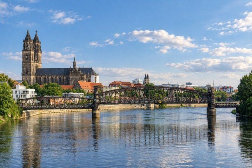 A historic bridge over a river, a prominent cathedral, and a clear blue sky. 4