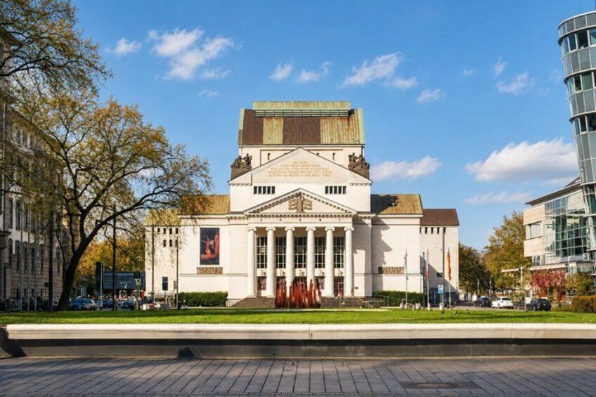A classical building with columns, a central entrance, and a flagpole. 5