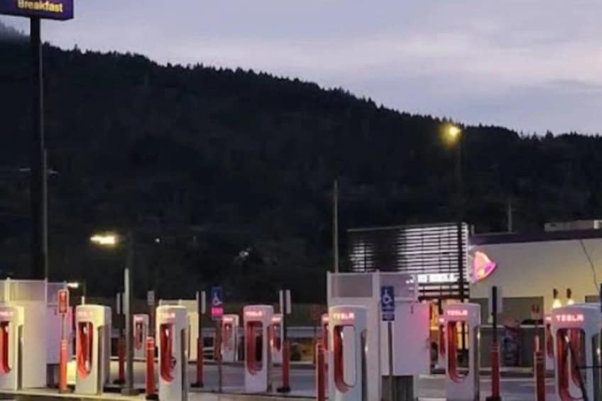 A Tesla charging station with a mountain in the background. 3