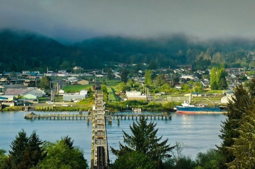A coastal town with a prominent pier extending into the water, surrounded by greenery and residential buildings. 5