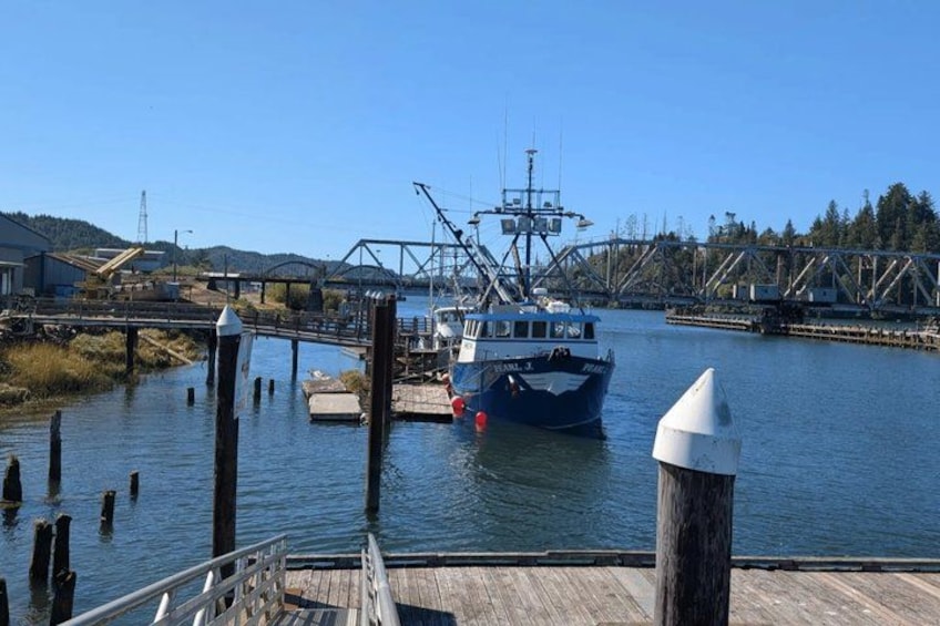 A boat docked at a pier with a bridge in the background. 4