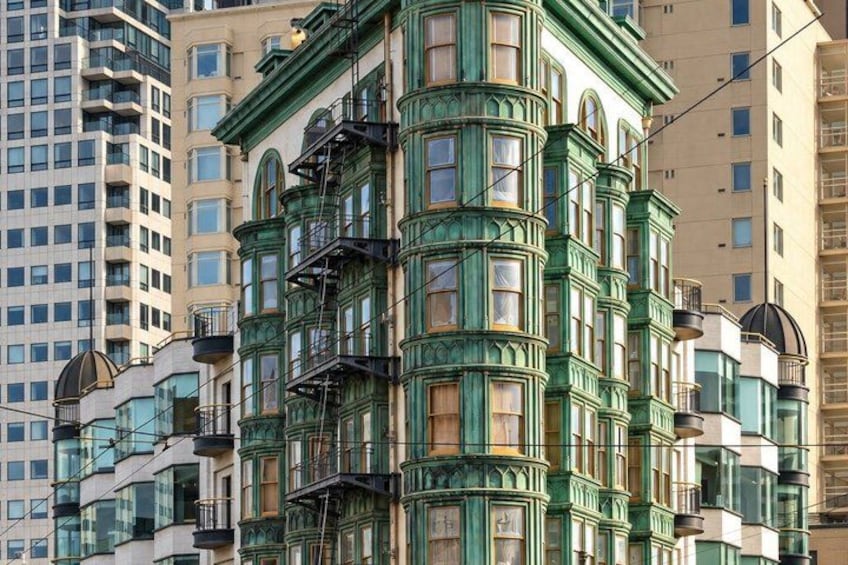 A historic building with ornate green trim and multiple windows. 5
