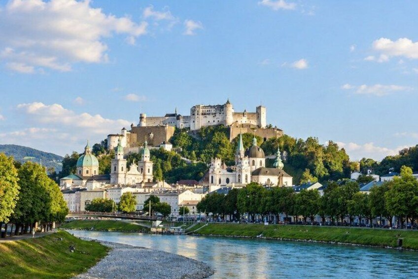 A historic castle on a hill, a river, and a cityscape with buildings. 5