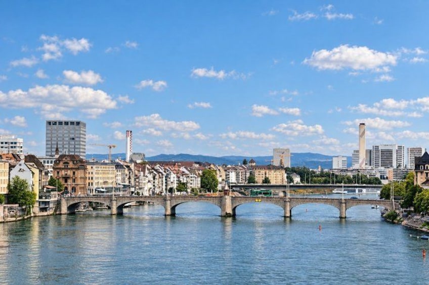 A river with multiple bridges, a cityscape with historic and modern buildings, and a clear sky. 2