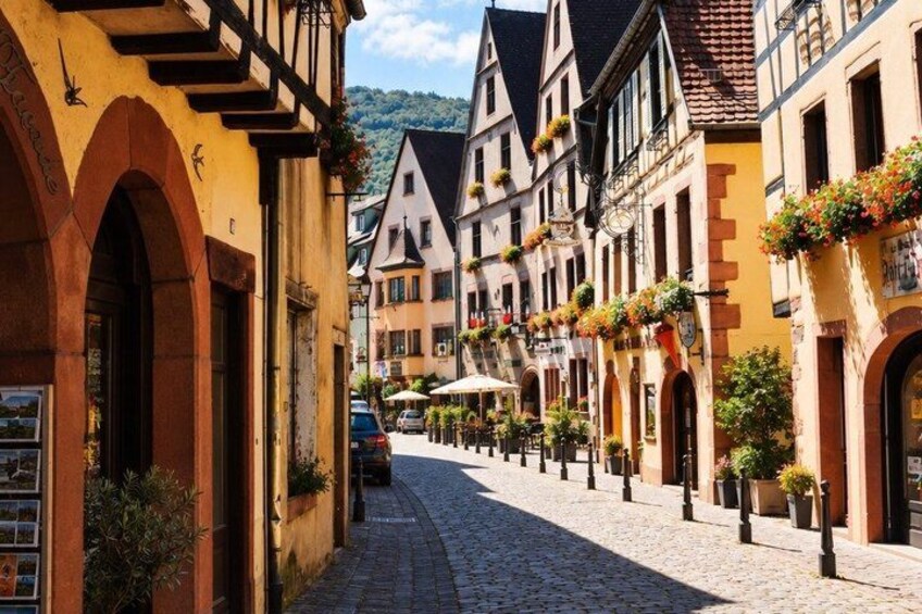A cobblestone street lined with traditional half-timbered buildings, some with flower boxes. 3