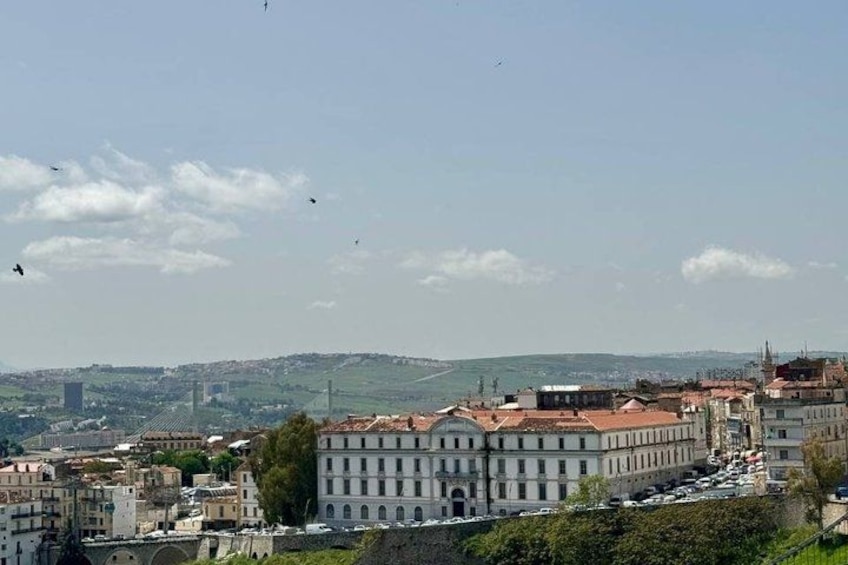 Un paysage urbain avec des bâtiments, un pont et une colline au loin. 2