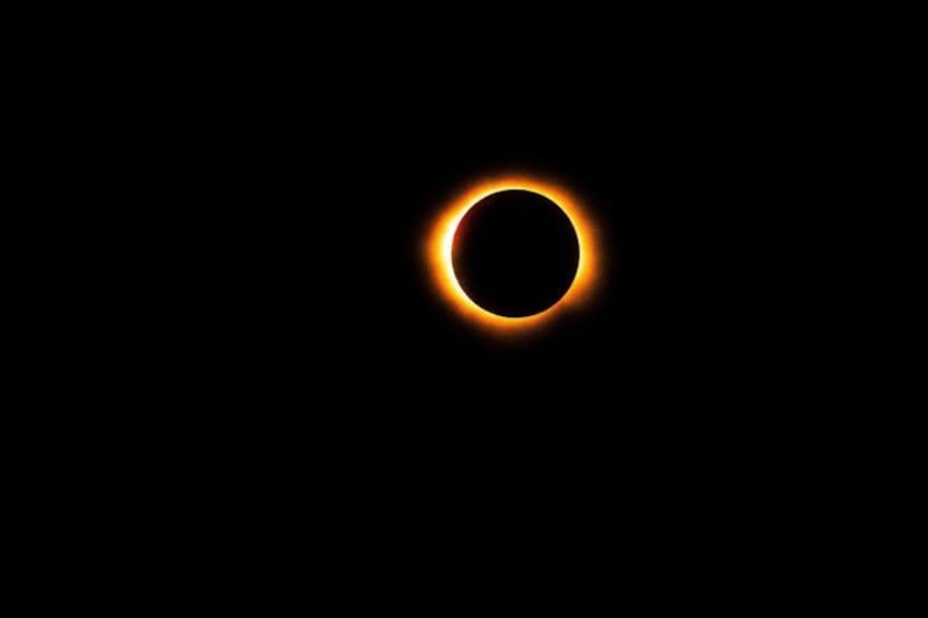 Une éclipse solaire avec un arrière-plan sombre et un anneau lumineux autour du soleil. 1