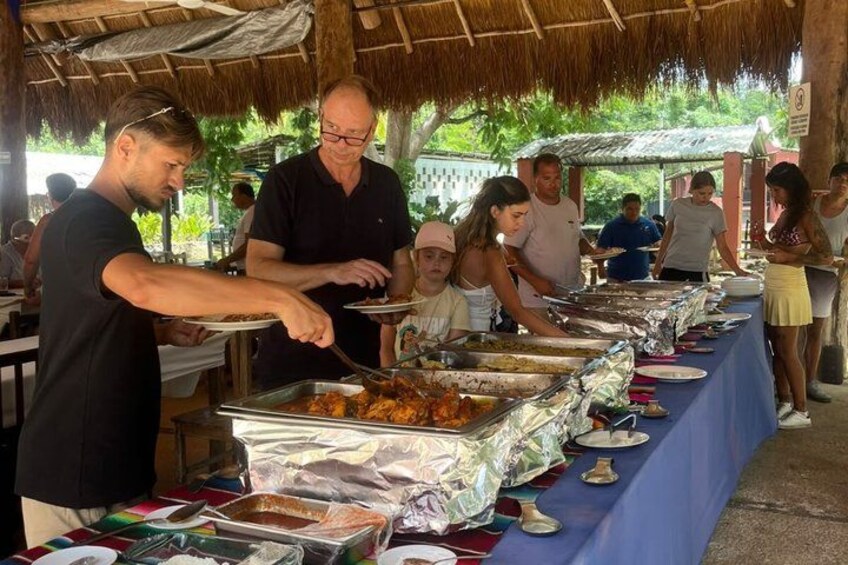 A buffet setup with people serving and serving food. 2