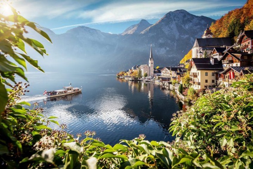 A lake with a boat, a church, and houses along the shore. 1