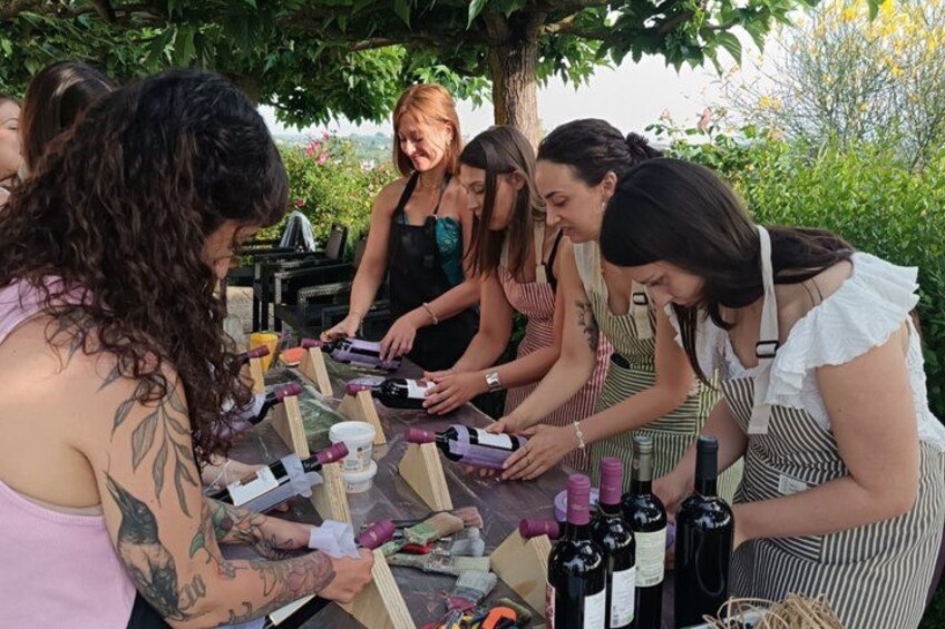 A group of people engaged in a wine tasting activity outdoors, surrounded by greenery. 5