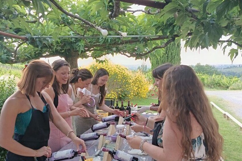 A group of people standing around a table with bottles, possibly for a social gathering. 3