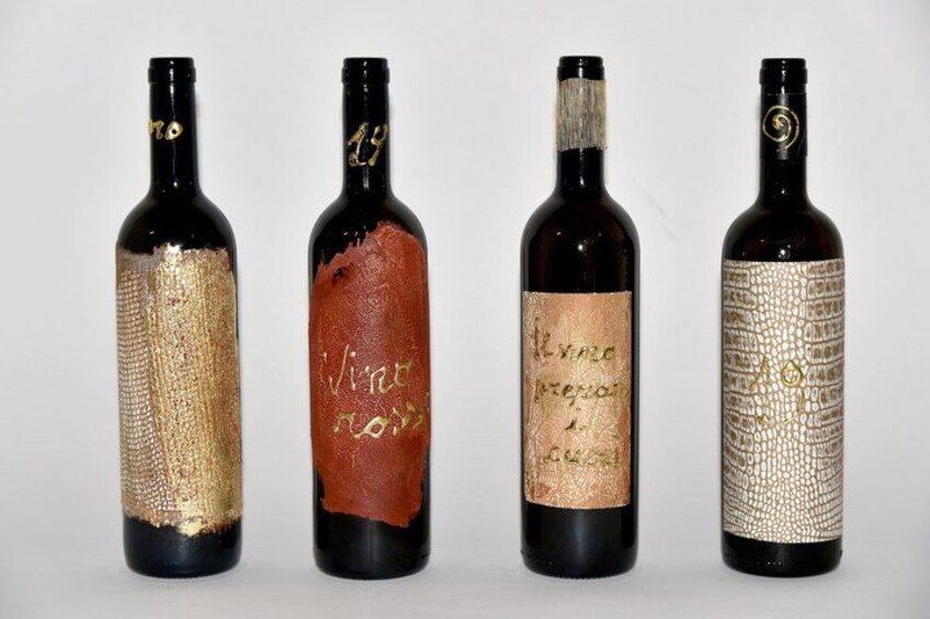 Four wine bottles with unique labels against a plain background. 1