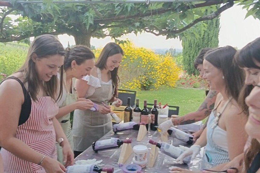 A group of people gathered around a table with bottles and glasses, likely preparing for a social event outdoors. 4