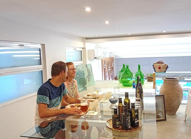 A modern interior with a dining table set for two, surrounded by decorative bottles and a large vase. 5