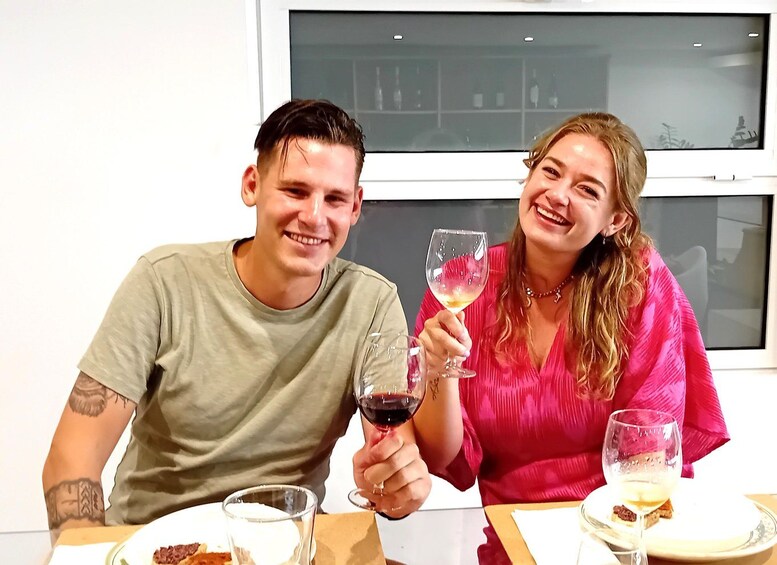 Two people sitting at a table with wine glasses. 4