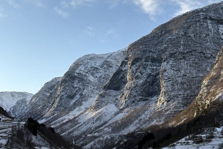 A snow-covered mountain range with rugged terrain and a clear sky. 3