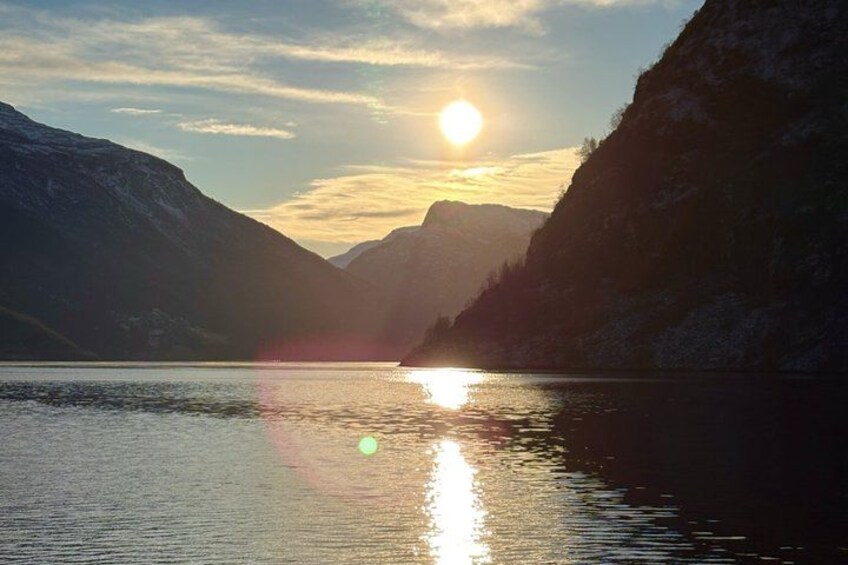 A mountain landscape with a lake reflecting the sun. 4