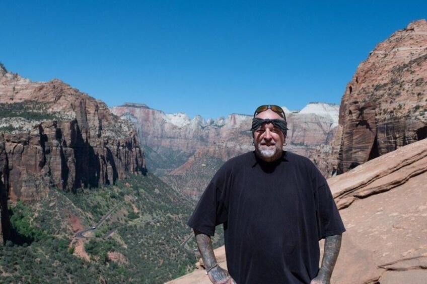 A person standing on a rocky outcrop with a canyon in the background. 3