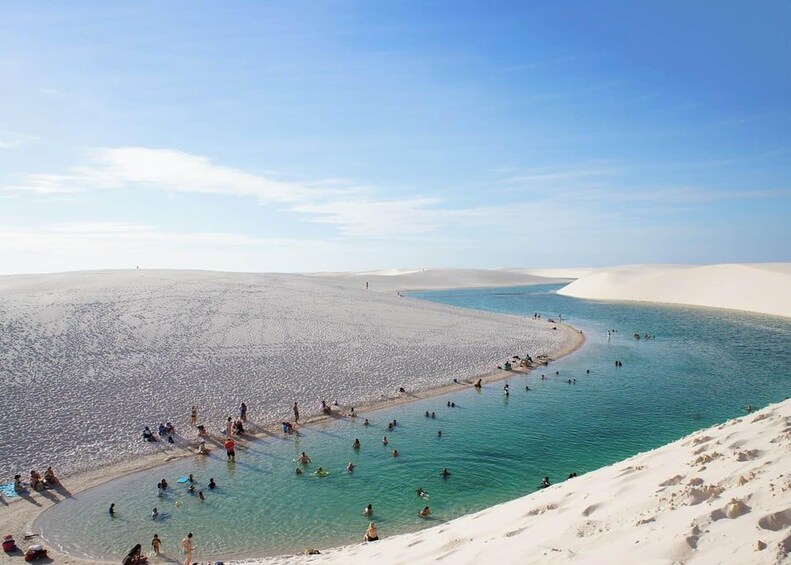 Ein Strand mit badenden und sonnenbadenden Menschen. 3
