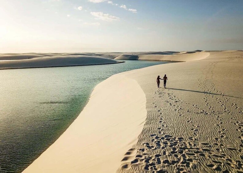 Wüstenlandschaft mit Sanddünen und einem Gewässer. 5