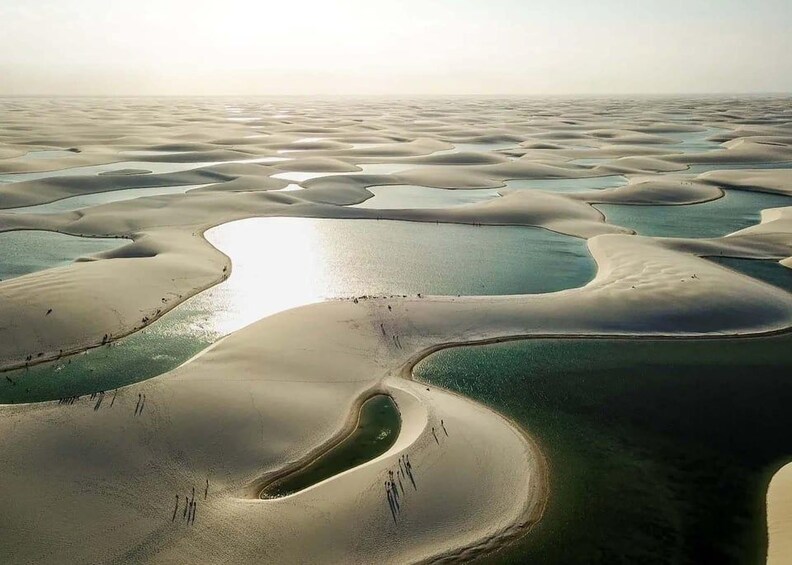Weite Wüstenlandschaft mit geschwungenen Wasserkanälen und einer entfernten Küstenlinie. 2
