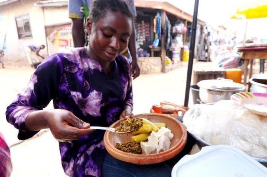 A person eating from a bowl with food items and a white plate on a table. 3
