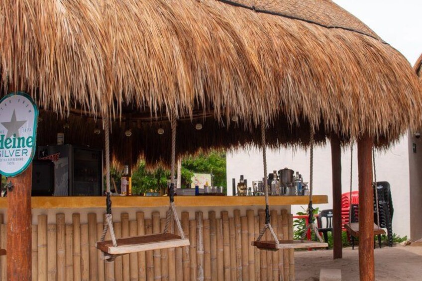 A thatched-roof bar with a sign for Heineken Silver. 5