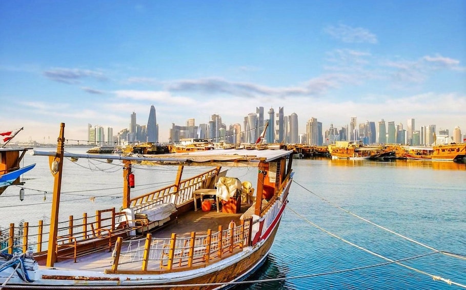 A boat docked at a harbor with a city skyline in the background. 3