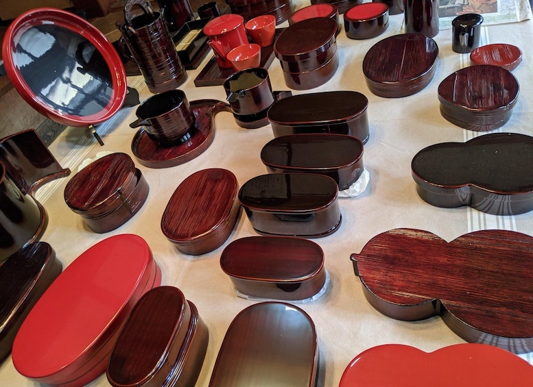 A variety of wooden containers with lids, some with red interiors, displayed on a table. 4