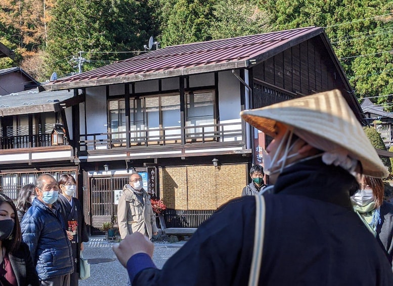 A traditional Japanese building with a tiled roof and wooden structure, surrounded by greenery. 2