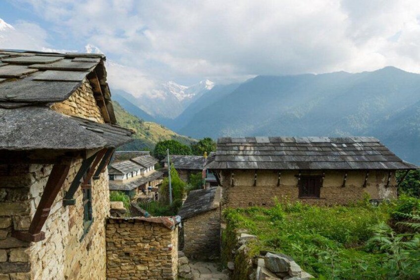 A mountainous village with traditional stone houses and a clear view of distant snow-capped peaks. 5