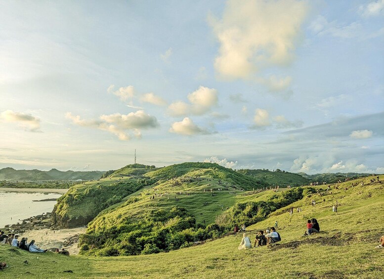A coastal landscape with rolling hills, a beach, and a distant tower. 2