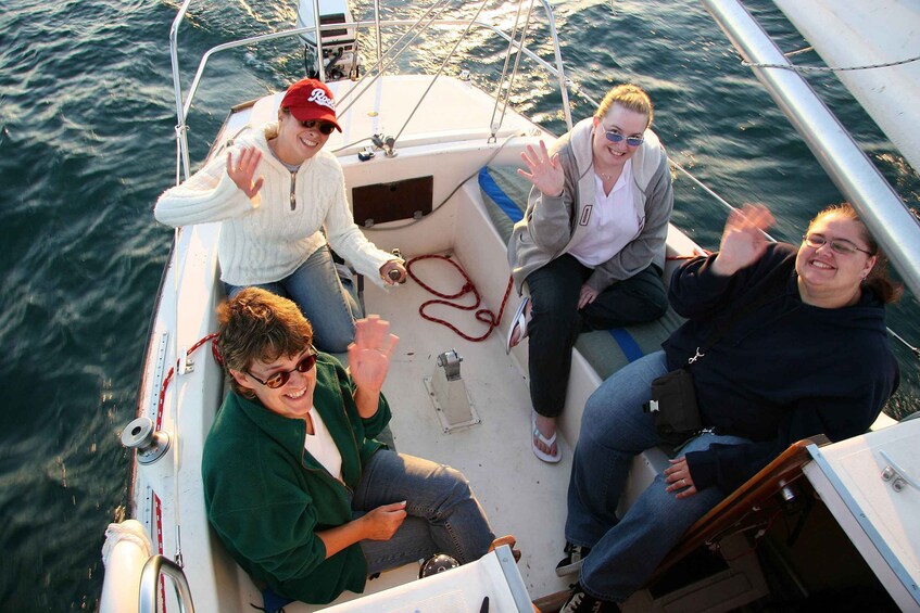 Four people on a boat with a wakeboard and a red rope. 2