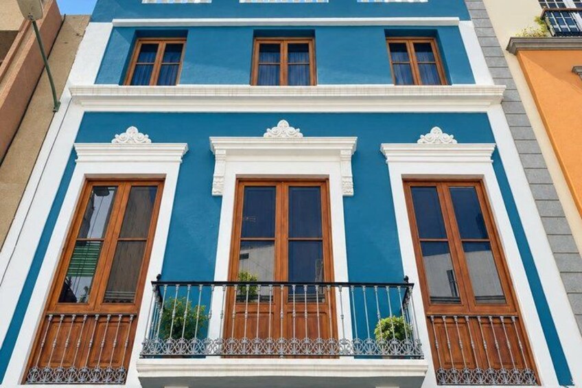 A blue building with white trim and wooden windows. 4