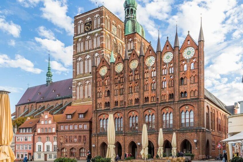 A historic red brick building with multiple spires and a clock tower. 4