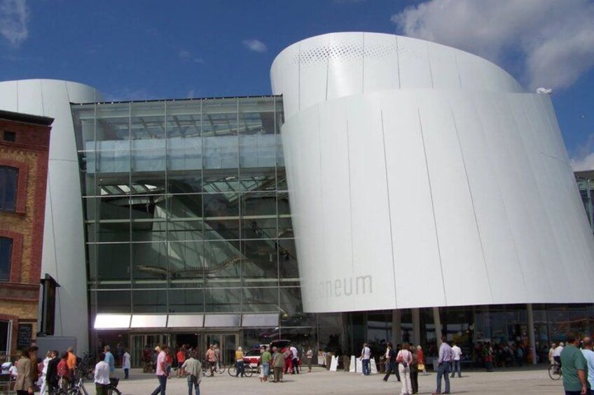 A modern building with a glass facade and a cylindrical structure. 5
