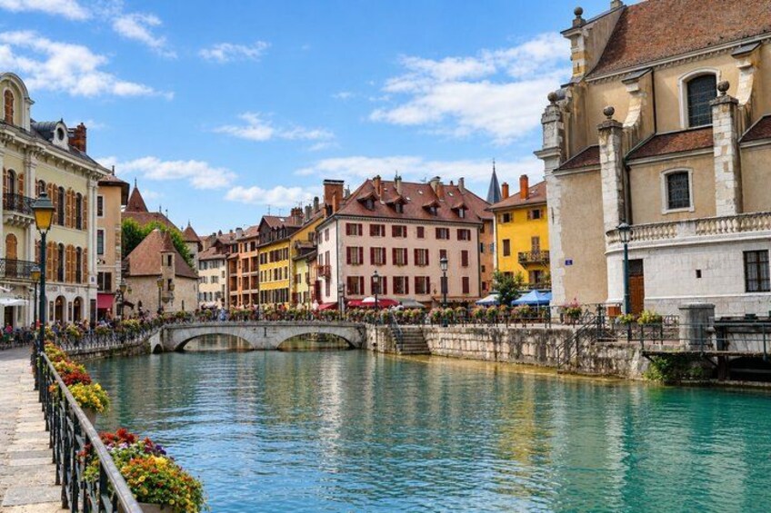 A river with a bridge, colorful buildings, and a clear sky. 3