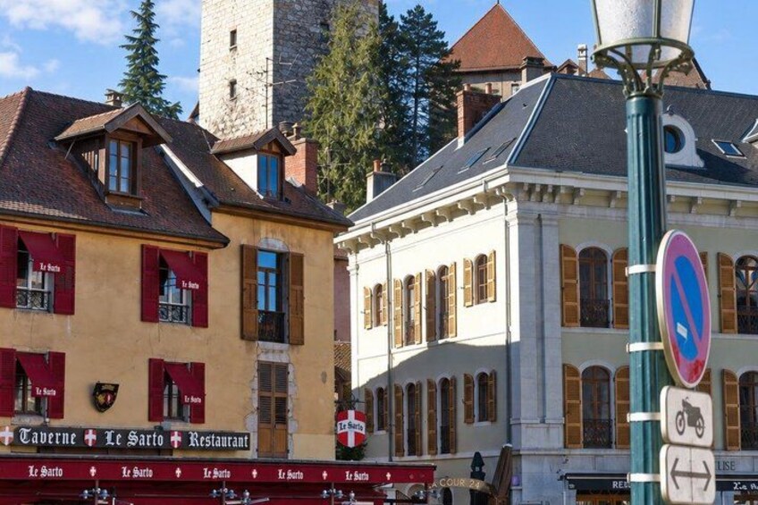 A street with buildings, a no parking sign, and a street lamp. 5