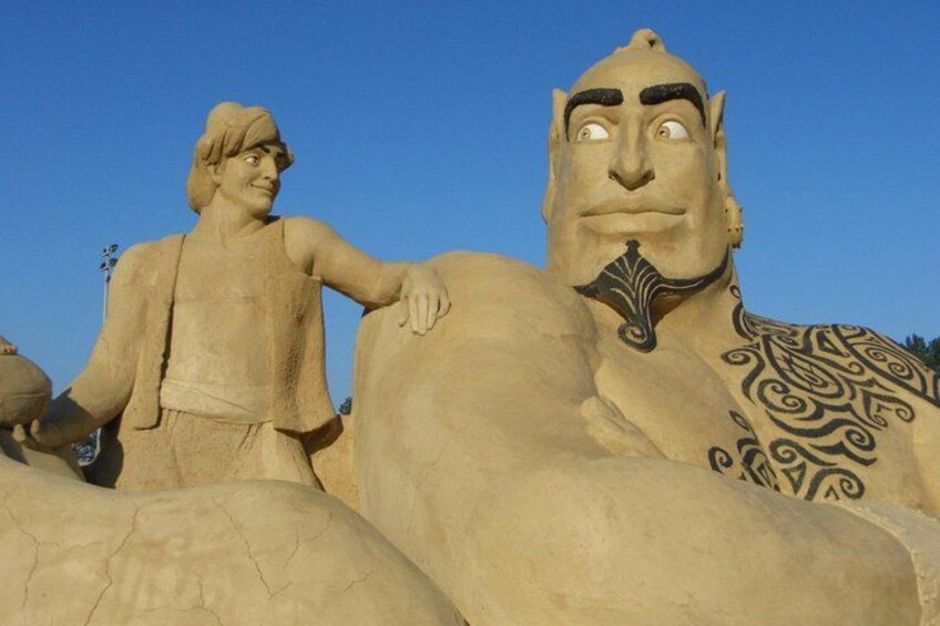 A large sand sculpture of a man and a child. 4