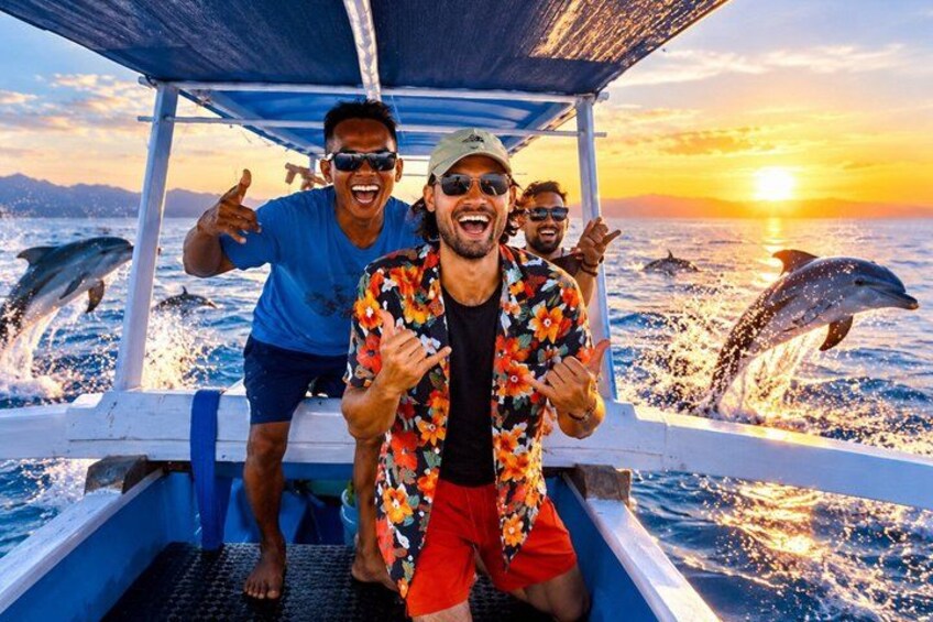 A boat with people and dolphins in the water. 1