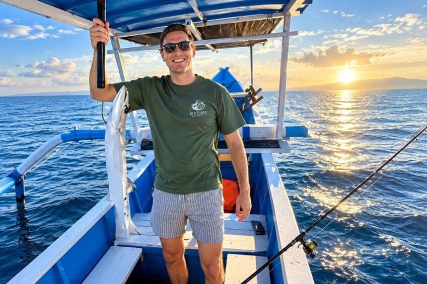 A person on a boat with a sunset in the background. 3