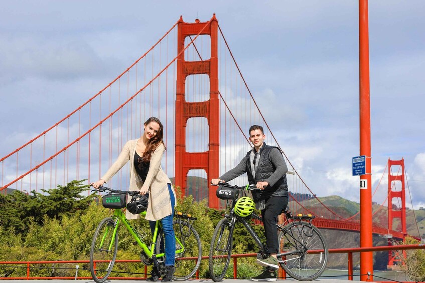Two people on bicycles with a red bridge in the background. 3