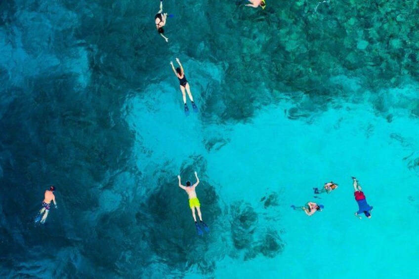 People swimming in a clear blue body of water. 3