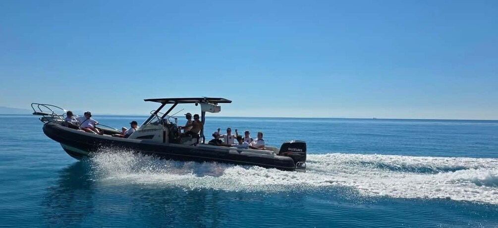 A speedboat with passengers on a clear day. 1
