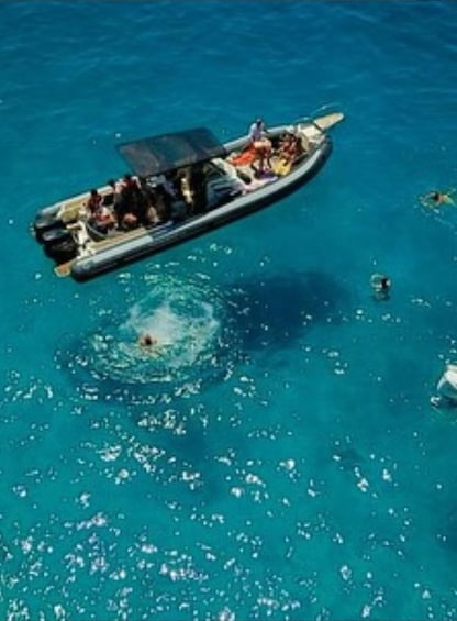 Un bateau avec des personnes à bord, naviguant sur une mer bleue et limpide. 1