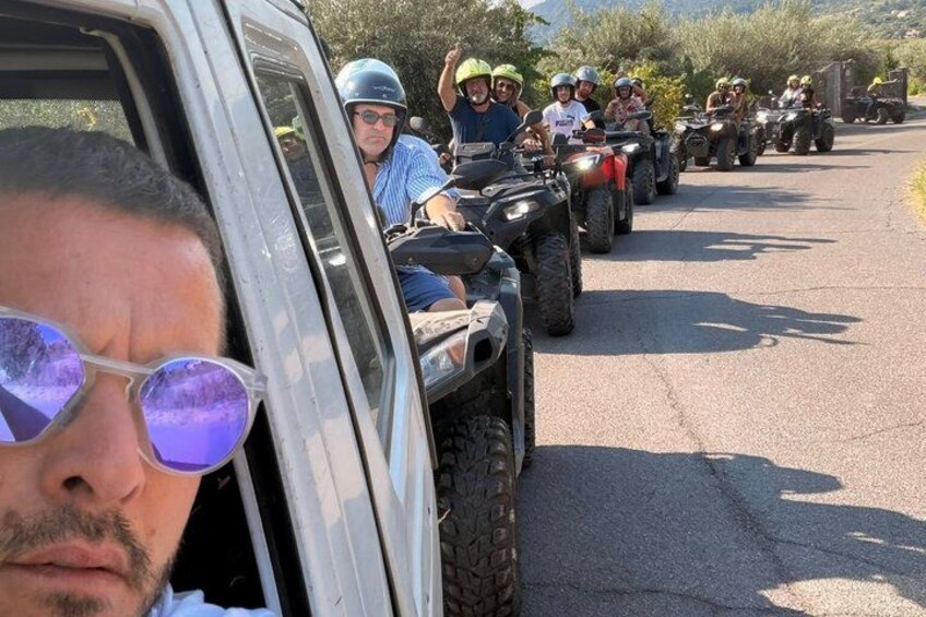 A convoy of off-road vehicles on a paved road. 1